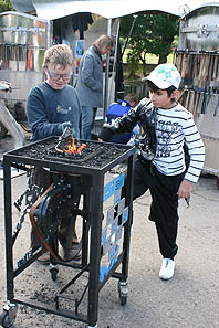 Kinder schmieden, im Hintergrund: das Mobile Schmiedelabor